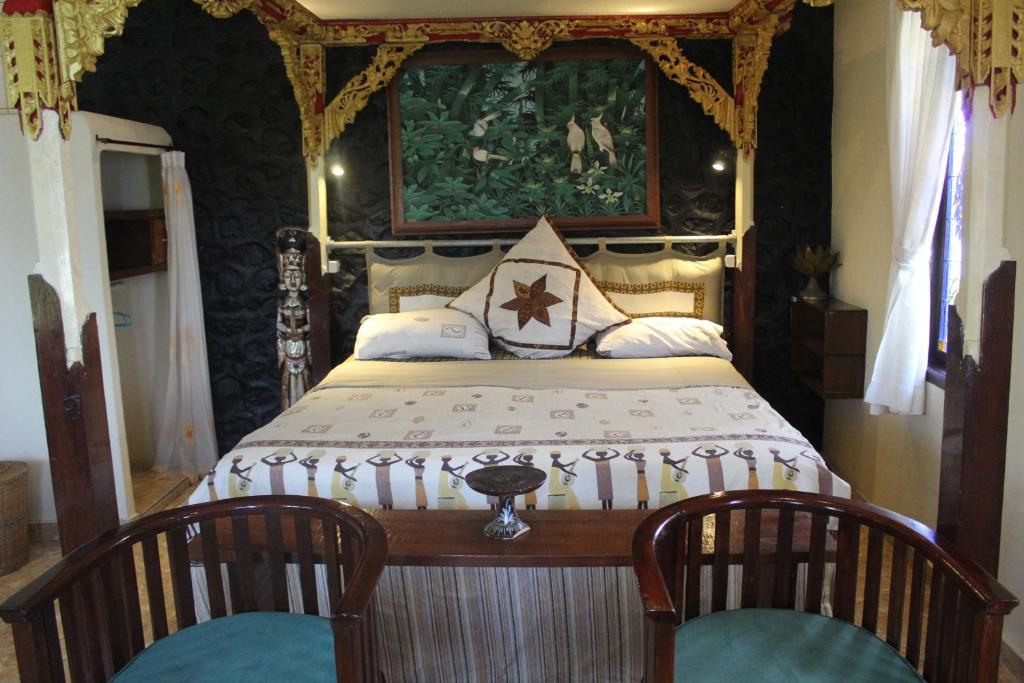 sypialnia z dużym łóżkiem z 2 krzesłami w obiekcie villa Arjuna w mieście Seraya