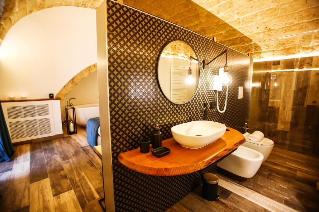 uma casa de banho com um lavatório e um espelho em Luna Federiciana Luxury Room & Spa em Altamura