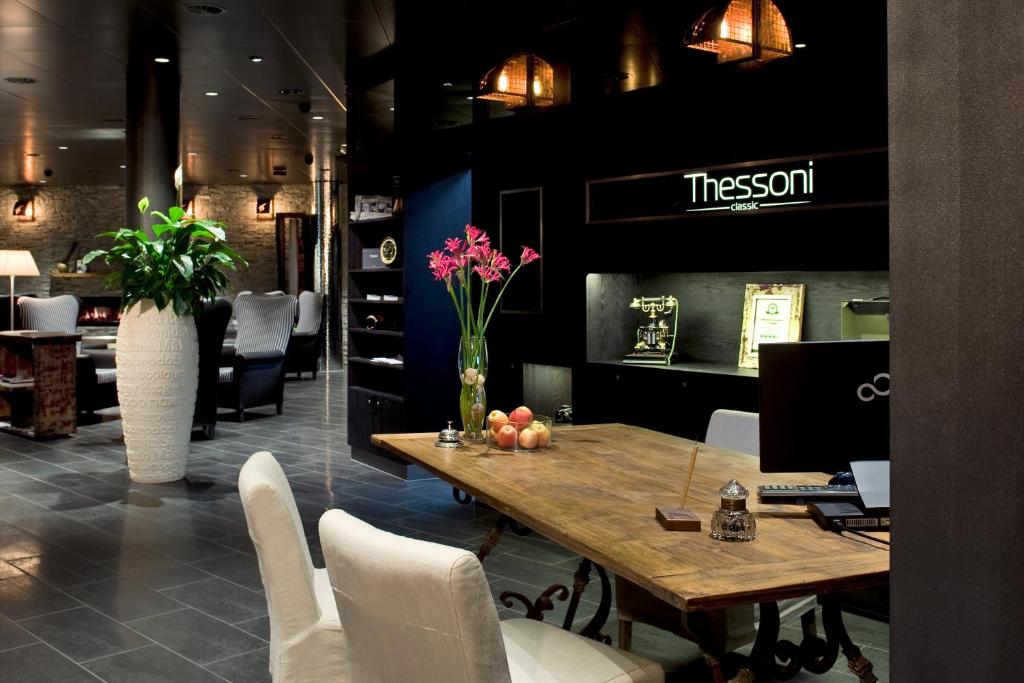 a dining room with a table and white chairs at Boutiquehotel ThessoniClassicZürich in Regensdorf