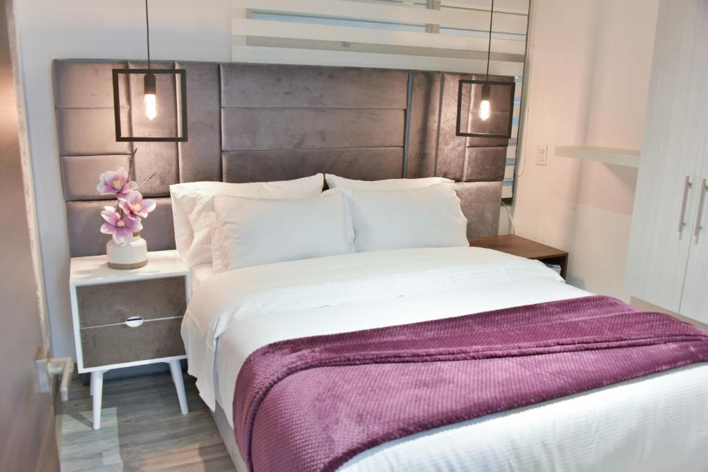 a bedroom with a large bed with a purple blanket at Casa Lua Hotel Spa in Chía