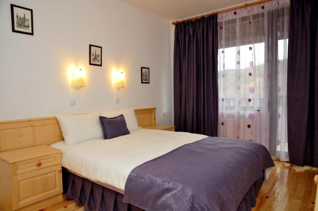 a bedroom with a large bed and a window at Family Hotel and Restaurant Plamena in Oreshak