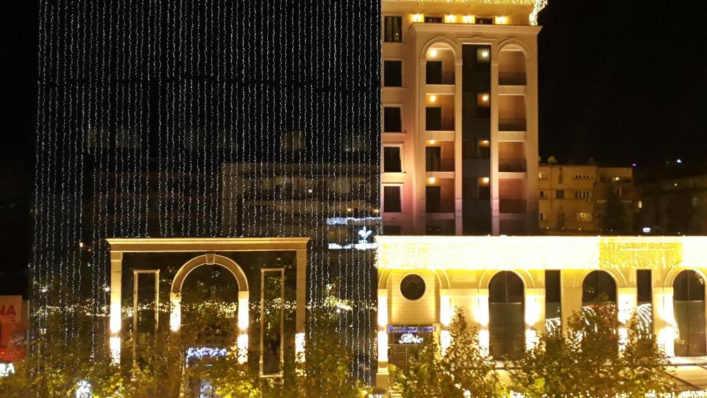 プリシュティナにあるApartment No 5の夜時計塔のある白い大きな建物
