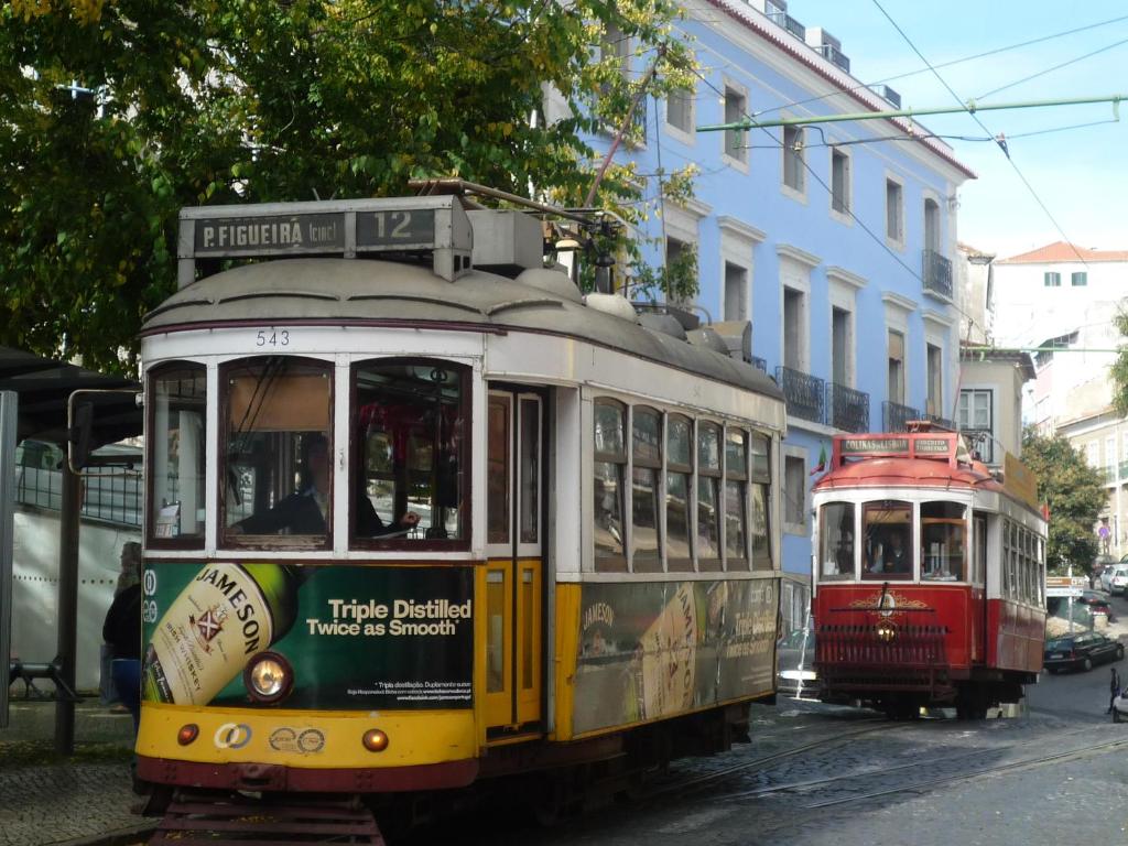 un tranvía en una calle de la ciudad con un tranvía en Casas do Castelo, en Lisboa