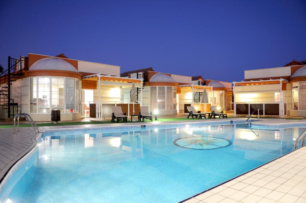 a large swimming pool in front of a building at Siesta Suites in Maspalomas