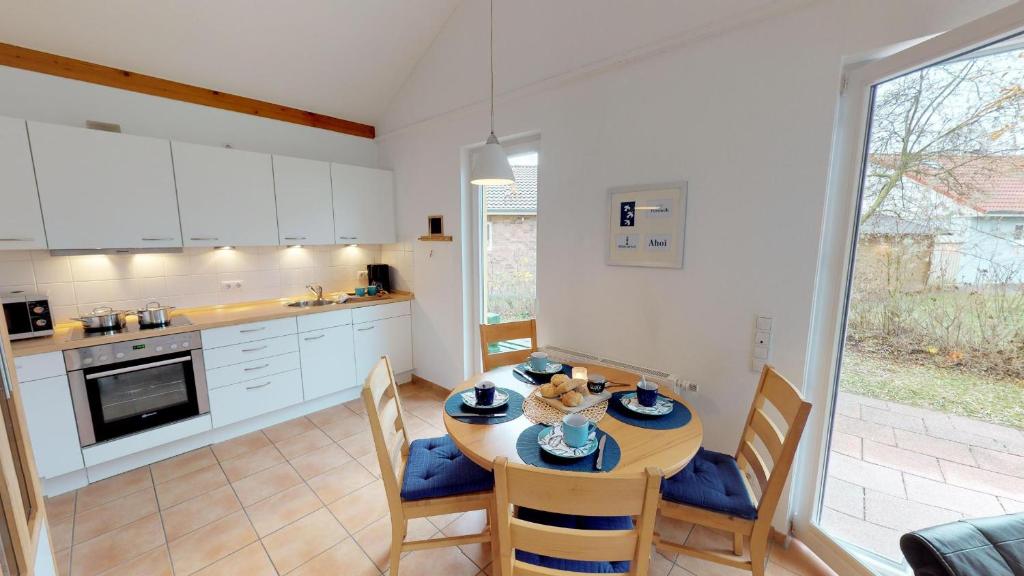 eine Küche und ein Esszimmer mit einem Tisch und Stühlen in der Unterkunft Feriendorf Südstrand Haus 44 in Pelzerhaken
