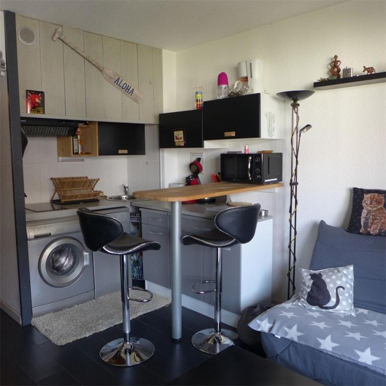 a small kitchen with two bar stools in a room at Réf 539, Seignosse Océan, Appartement à 150m de la plage, proche commerces, 4 personnes in Seignosse