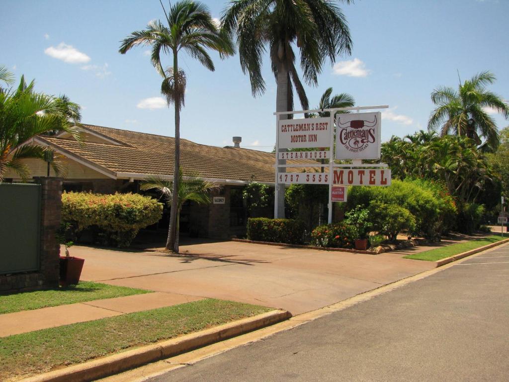 ein Schild für ein Motel auf einer Straße mit Palmen in der Unterkunft Cattleman's Rest Motor Inn in Charters Towers