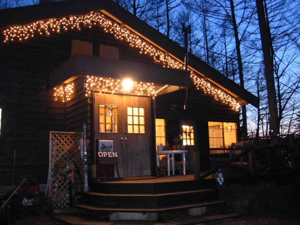 une maison avec des lumières de Noël à l'avant dans l'établissement Lodge Stack Point, à Narusawa