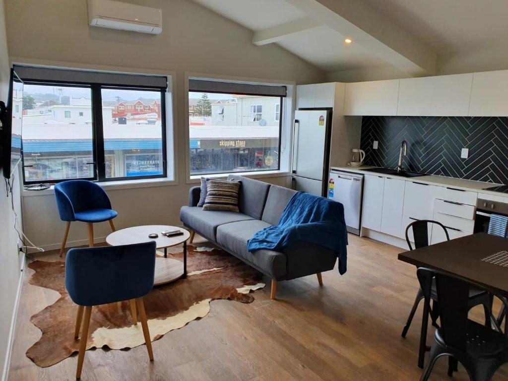 sala de estar con sofá y mesa en U Suites Kilbirnie, en Wellington