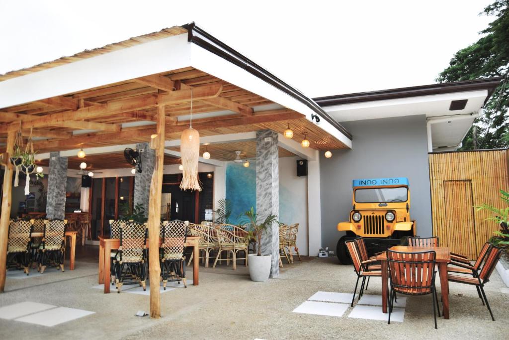 eine Terrasse mit einem Grill sowie Tischen und Stühlen in der Unterkunft GUNI GUNI HOSTEL in Puerto Princesa