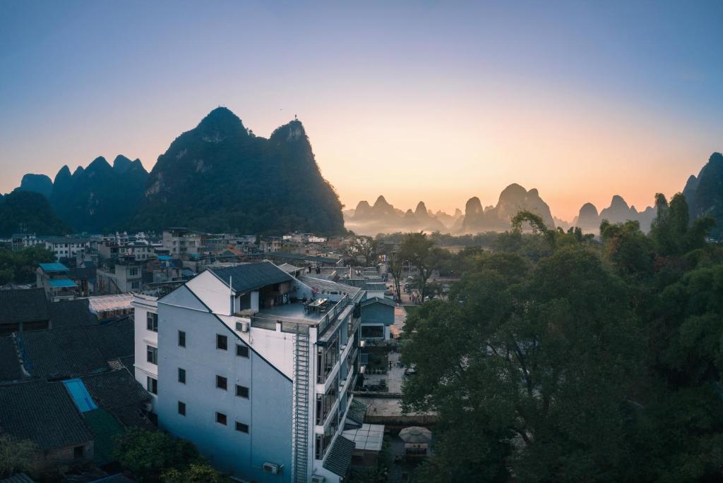 uitzicht op een stad met bergen op de achtergrond bij Ron Inn Xingping Hepan Xiaozhu in Yangshuo