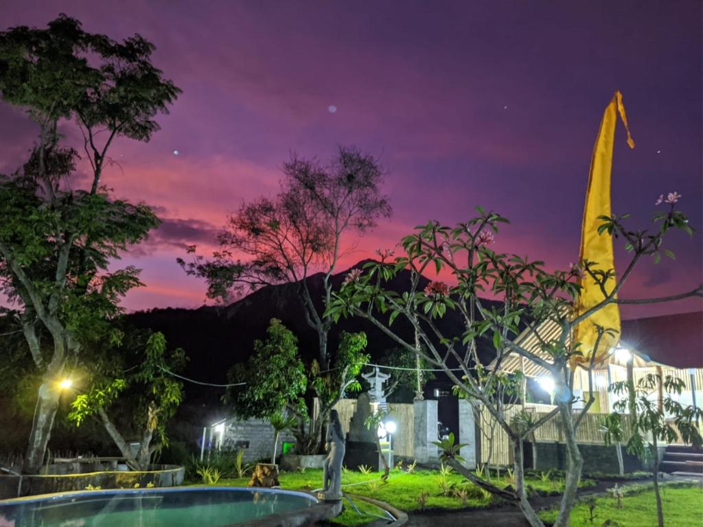 een nachtelijk uitzicht op een park met een vlag bij Kintamani Cabins in Kintamani