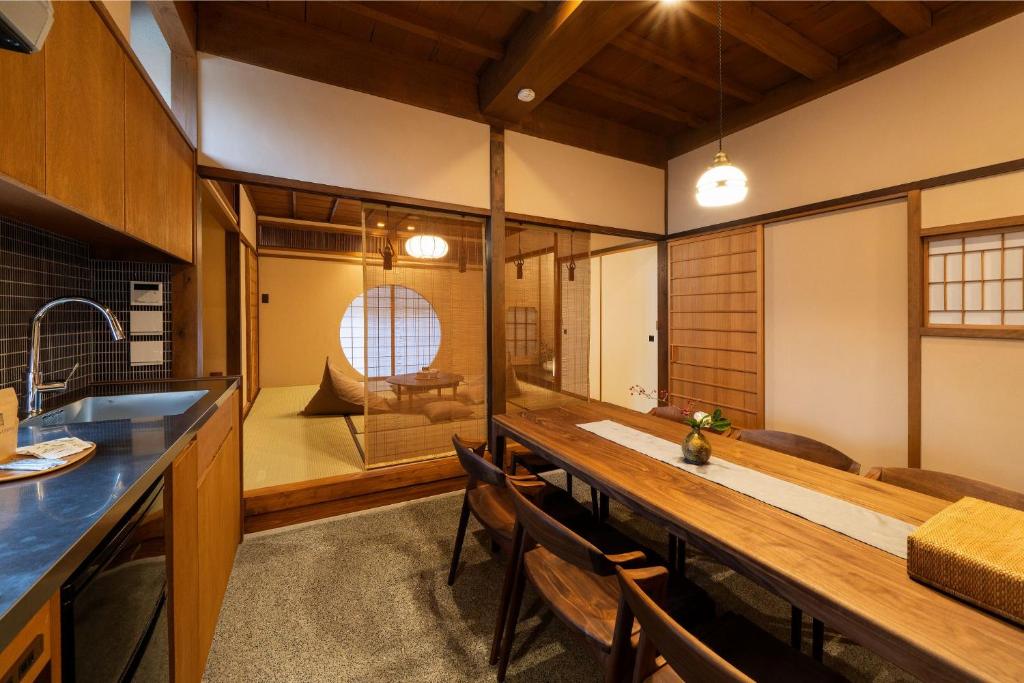 eine Küche mit einem langen Holztisch in einem Zimmer in der Unterkunft Kurohoro Machiya House in Kanazawa