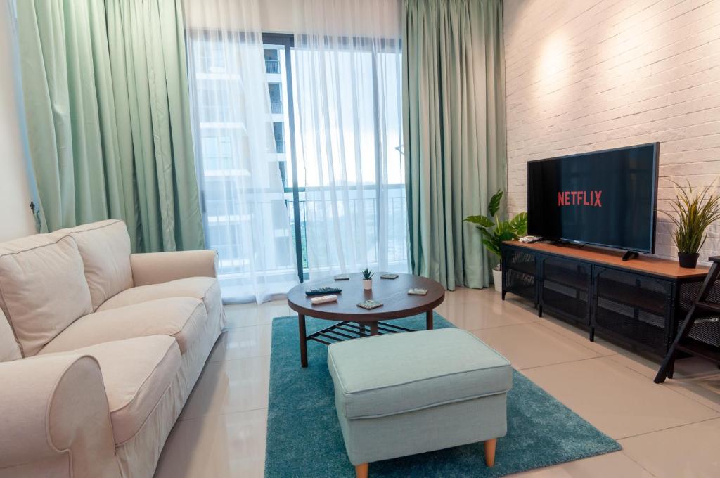 a living room with a couch and a tv at Condo near Bukit Jalil by Idealhub in Kuala Lumpur