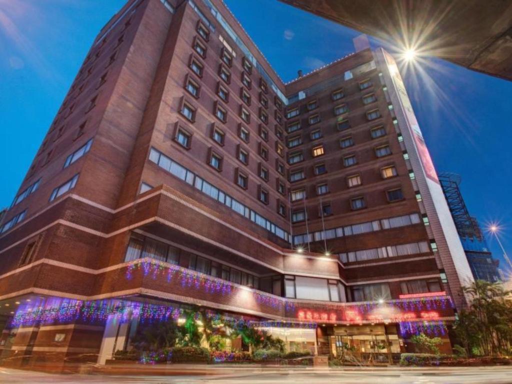 a tall building with lights in front of it at Hotel Riverview Taipei in Taipei