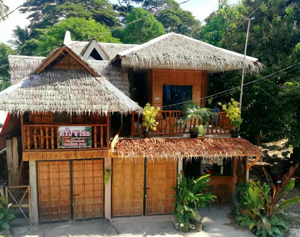 ein kleines Haus mit einem Strohdach in der Unterkunft RYJ's Inn in Siquijor