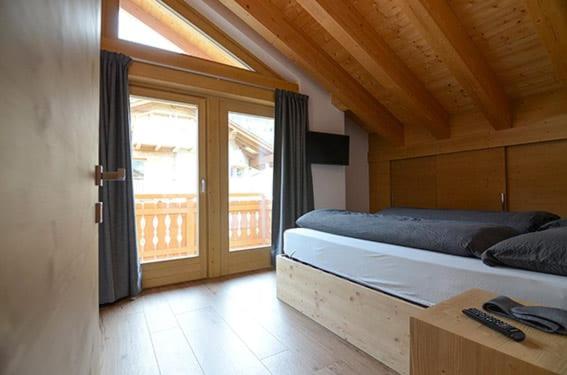 a bedroom with a bed and a large window at Chalet Paul in Livigno
