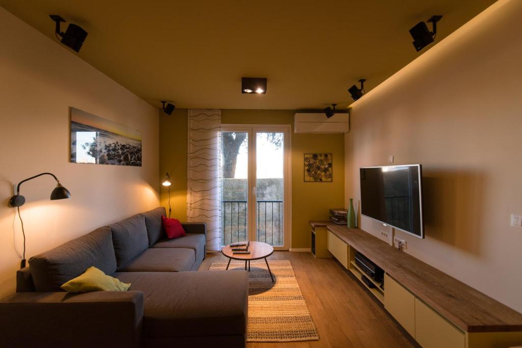 sala de estar con sofá y TV de pantalla plana en The Wall Apartment en Zadar