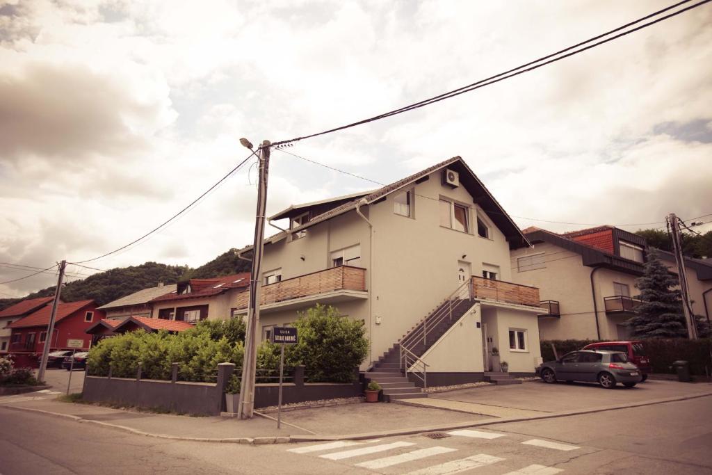 a white house with a staircase on the side of a street at Rooms Medved in Samobor