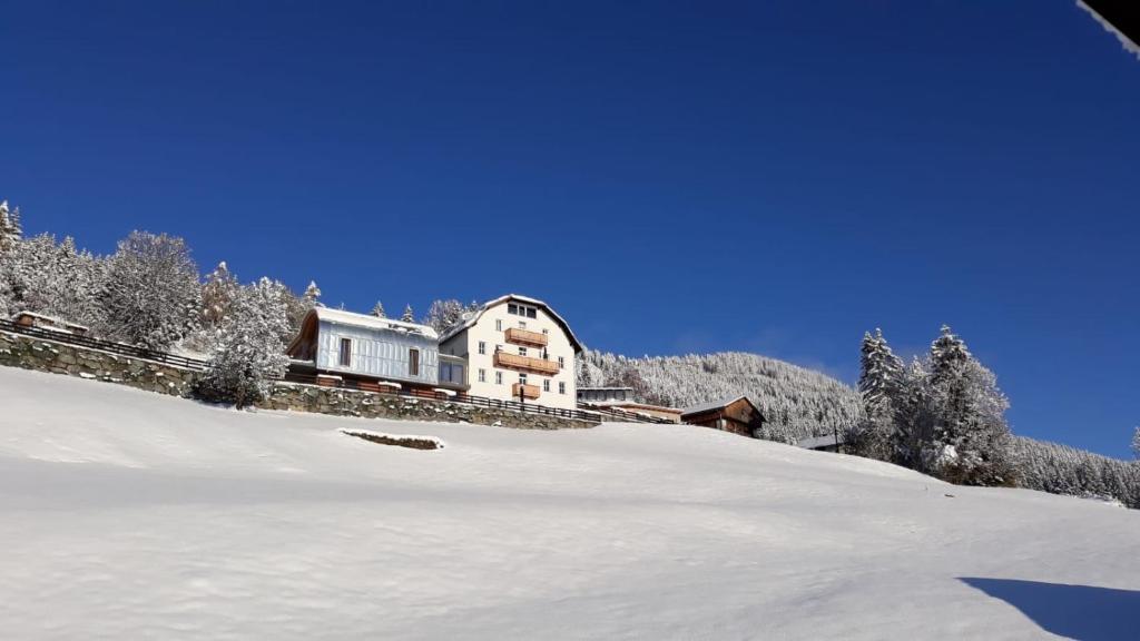 ein Haus auf einem schneebedeckten Hügel in der Unterkunft Kieferhof in Iselsberg