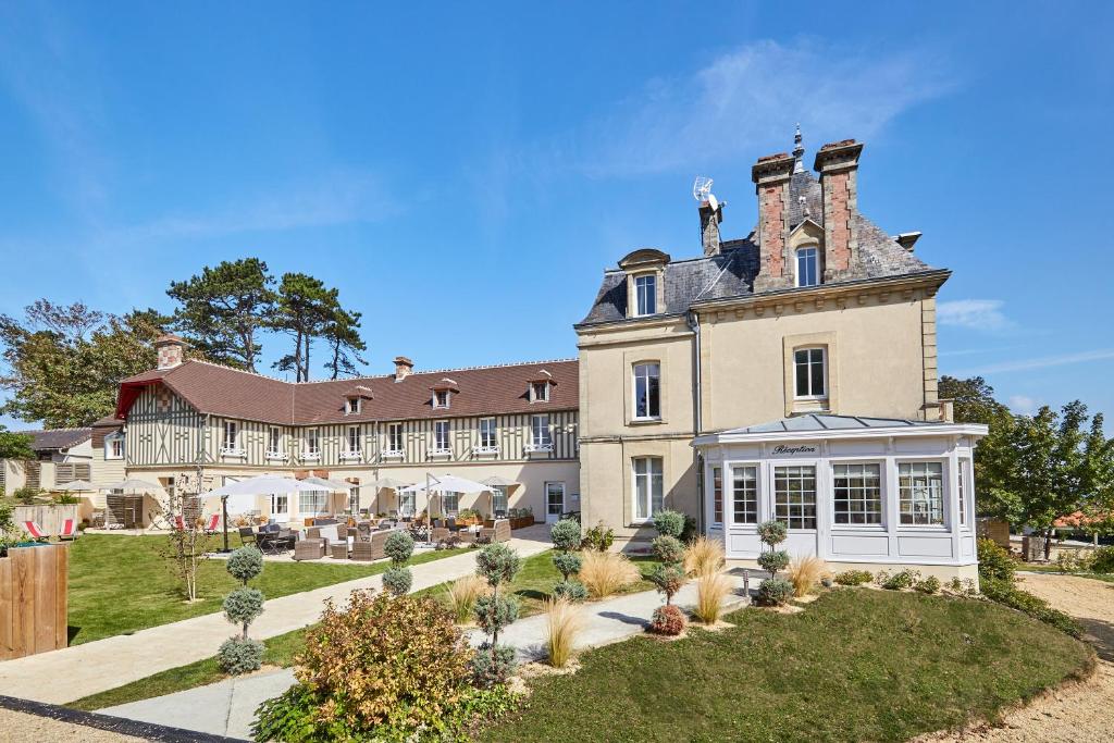 een uitzicht op een groot huis met een tuin bij Les Villas d'Arromanches, Teritoria in Arromanches-les-Bains