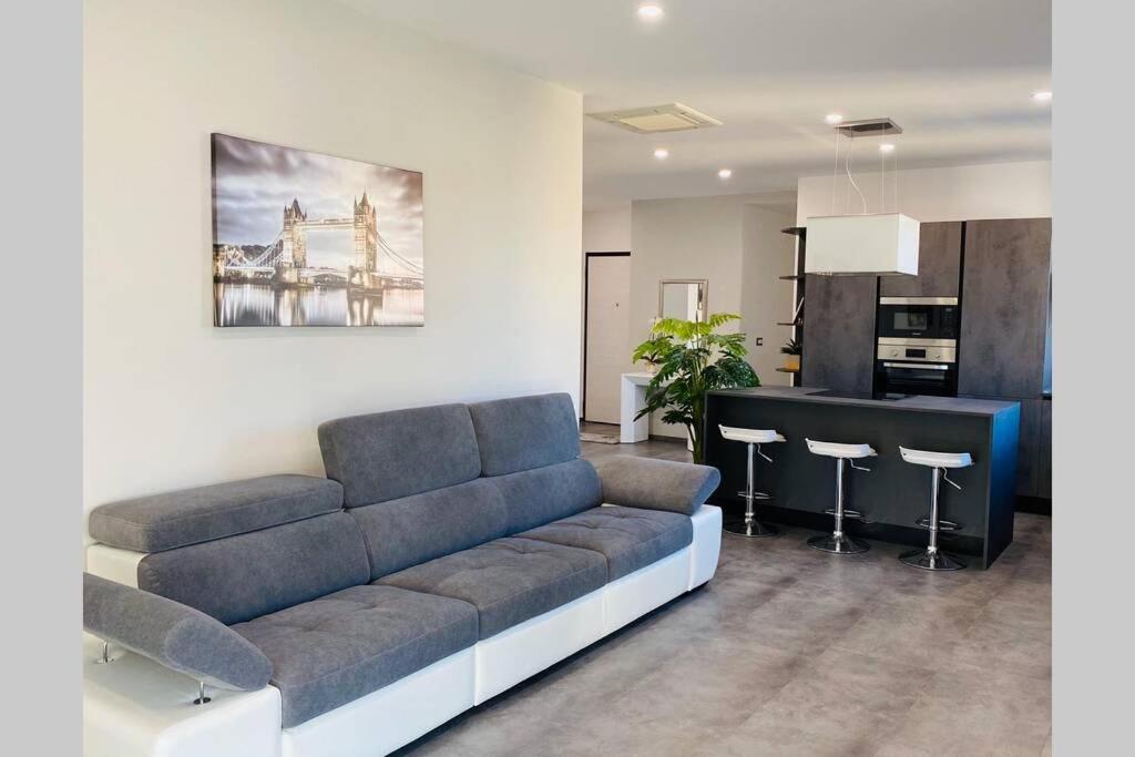 sala de estar con sofá y cocina en Appartamento Moderno I Luxury Design, en Soverato Marina