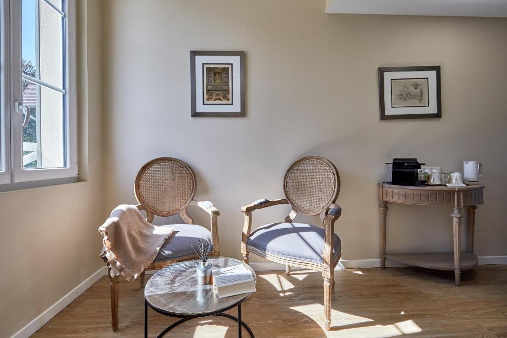 a living room with two chairs and a table at Les Villas d'Arromanches, Teritoria in Arromanches-les-Bains
