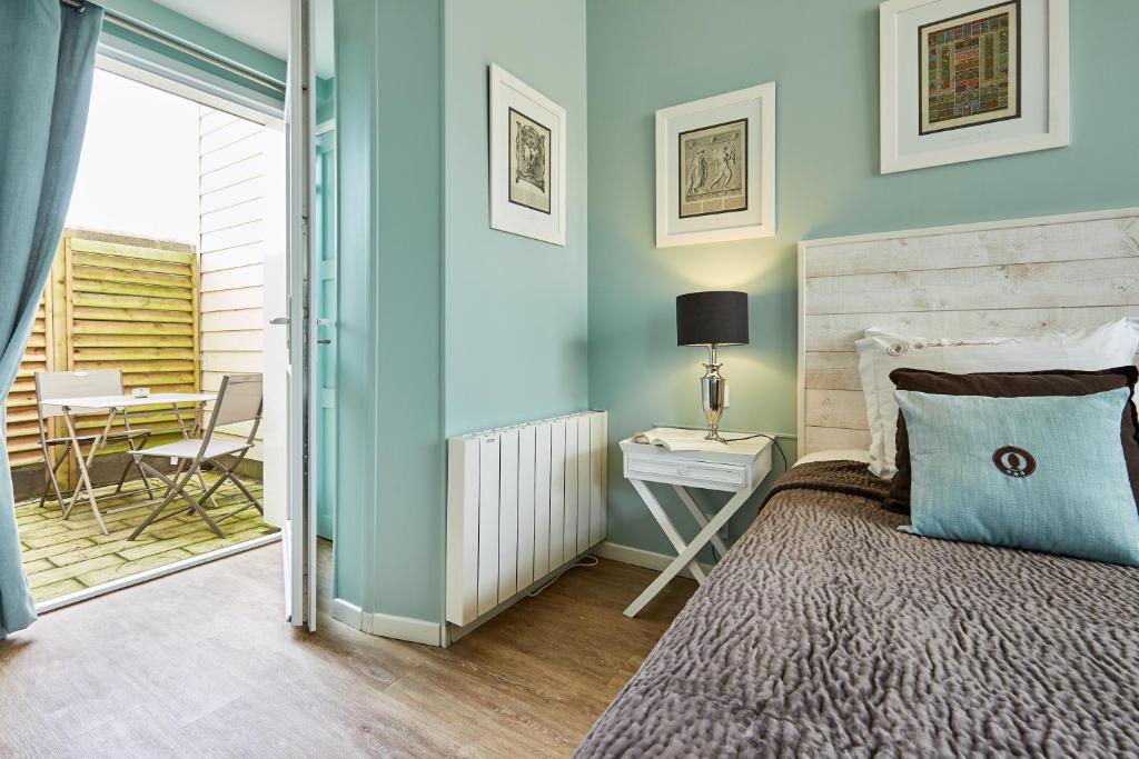 a bedroom with a bed and a table with a chair at Les Villas d'Arromanches, Teritoria in Arromanches-les-Bains
