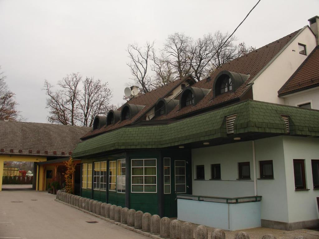 ein Gebäude mit einem grünen Dach auf einer Straße in der Unterkunft B&B Janežič in Ljubljana