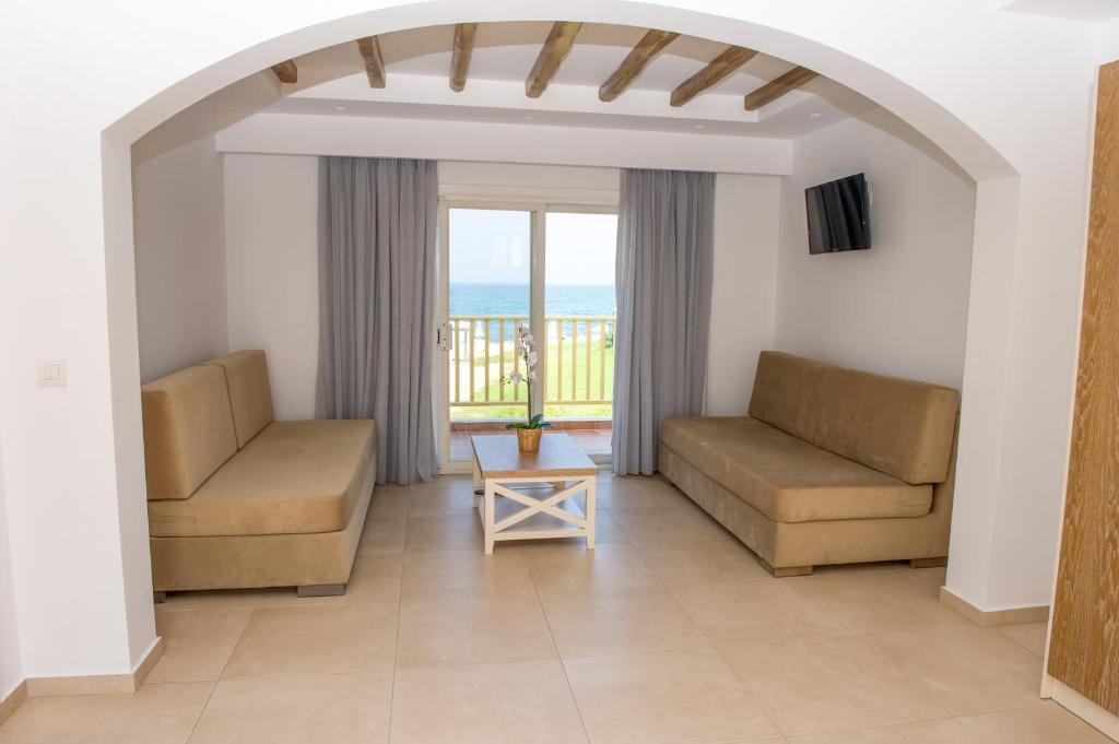 a living room with two couches and a view of the ocean at Mastichari Bay Hotel in Mastihari