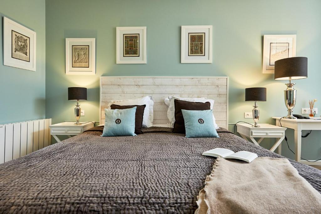 a bedroom with a bed with two tables and two lamps at Les Villas d'Arromanches, Teritoria in Arromanches-les-Bains