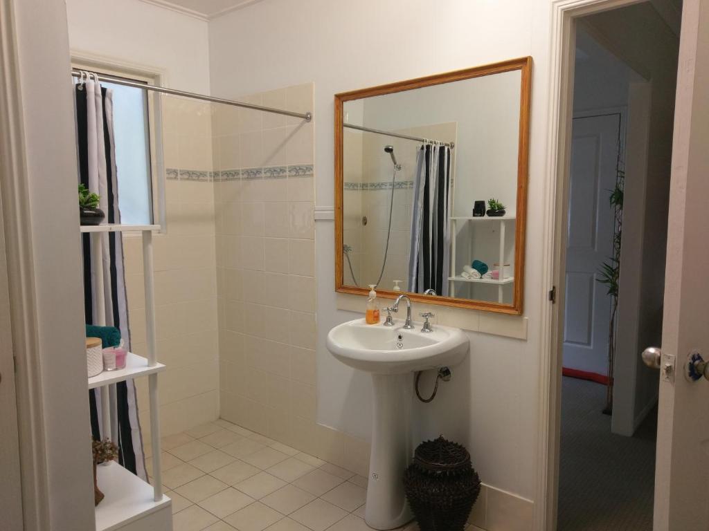 een badkamer met een wastafel en een spiegel bij Nomads Rest in Gympie