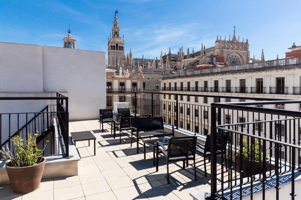 a balcony with chairs and a view of a city at Welldone Cathedral Suites in Seville