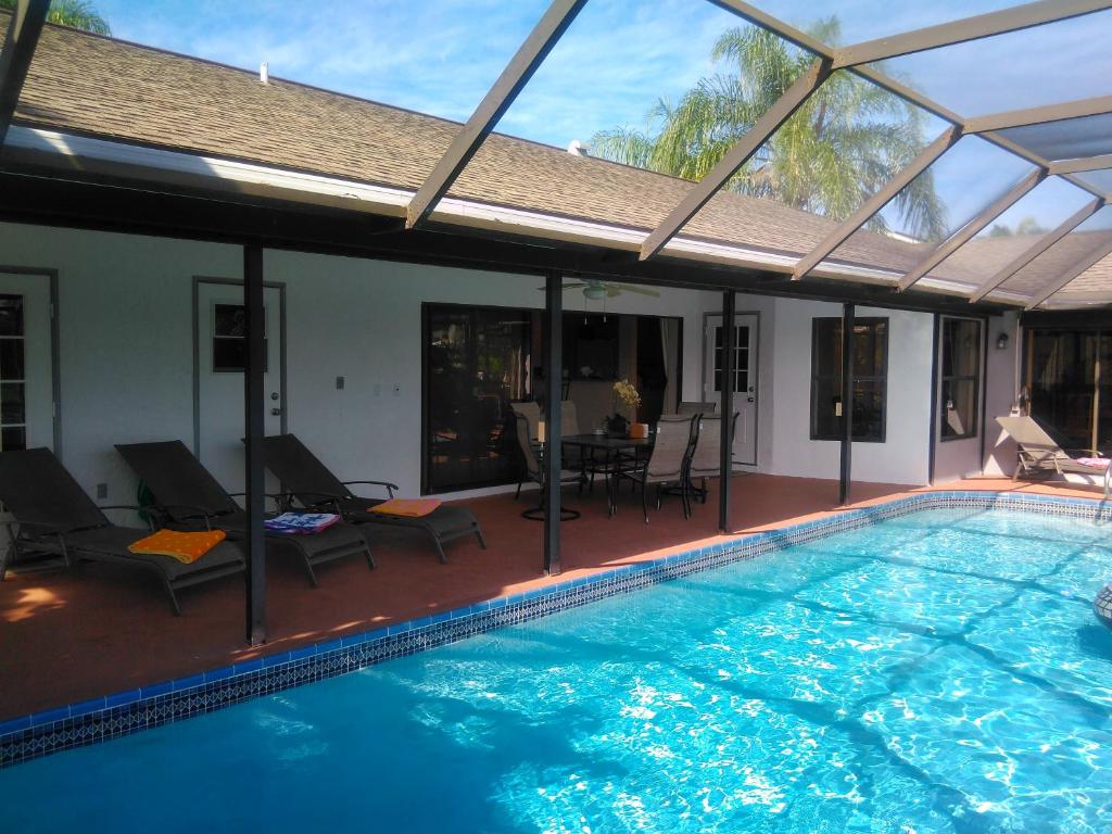 een zwembad met een patio en een huis bij Villa Angel's Haven in Cape Coral