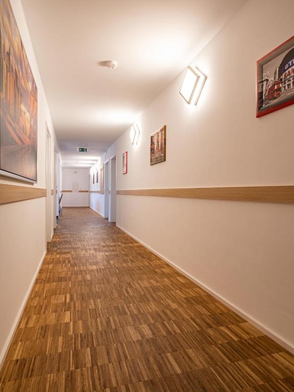 a hallway of an art gallery with wood floors at Pension zum Bergmann in Böhlen