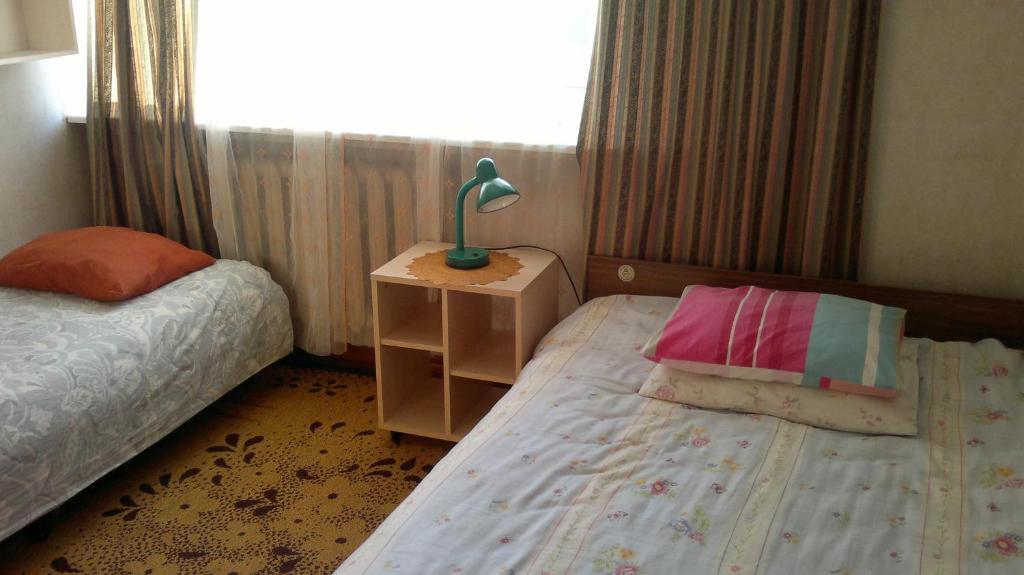 a bedroom with two beds and a lamp on a night stand at Tuule 1 Home Accommodation in Kuressaare
