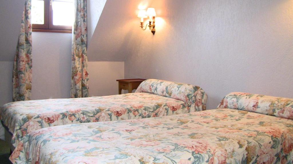 2 camas en una habitación pequeña en Auberge Des Potiers en Jouy-le-Potier