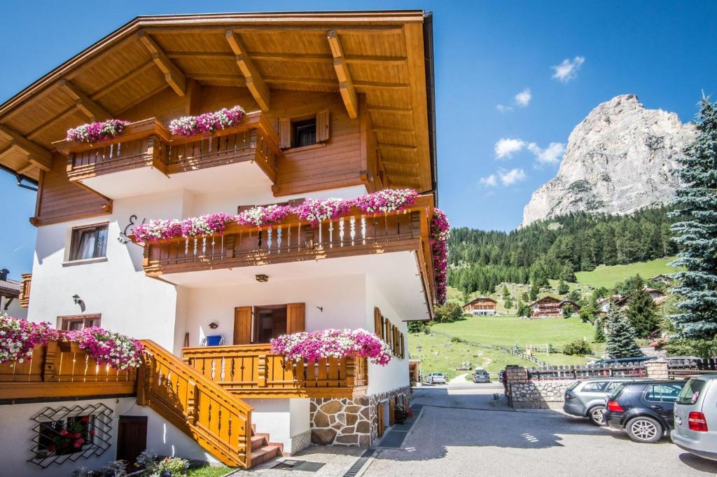 a house in the mountains with flowers on the balconies at Garni Edera in Corvara in Badia