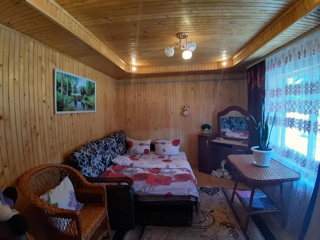 um quarto com uma cama, um sofá e uma mesa em Затишні Карпати)) em Verkhovyna