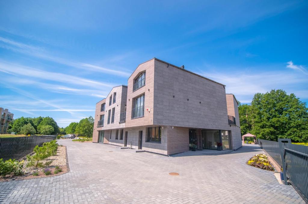 un grand bâtiment en briques sur une route en briques dans l'établissement Vila JŪRALUX, à Palanga