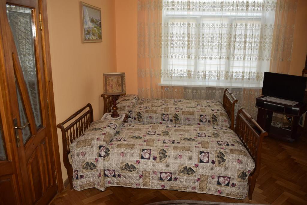 a bedroom with two beds and a window at Apartment Orgelsaal in Chernivtsi