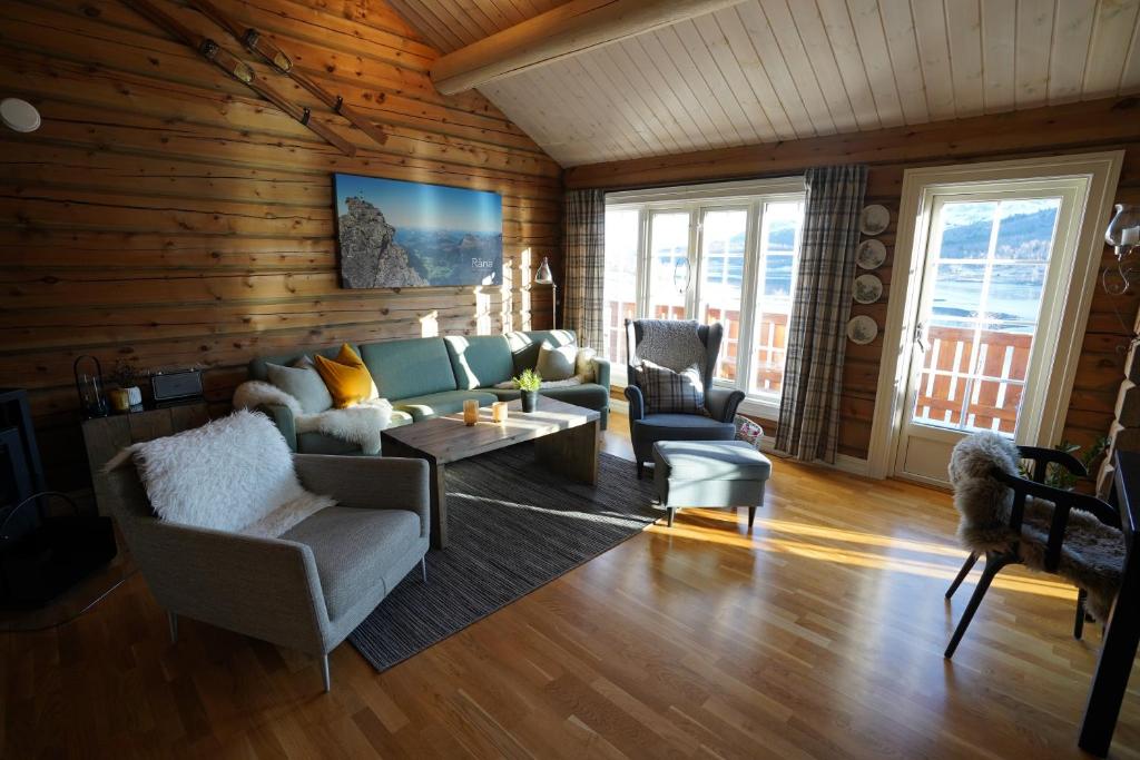 a living room with a couch and chairs and a table at Lake View Apartment 2 bedrooms and loft in Stranda