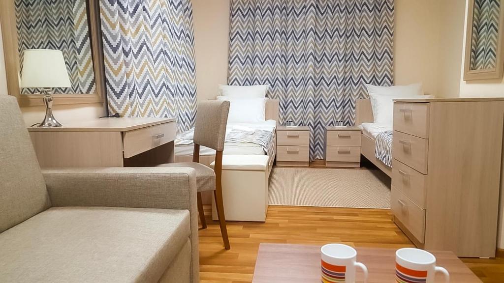 um pequeno quarto com 2 camas e uma secretária em мини-отель Arctic Hotel em Murmansk