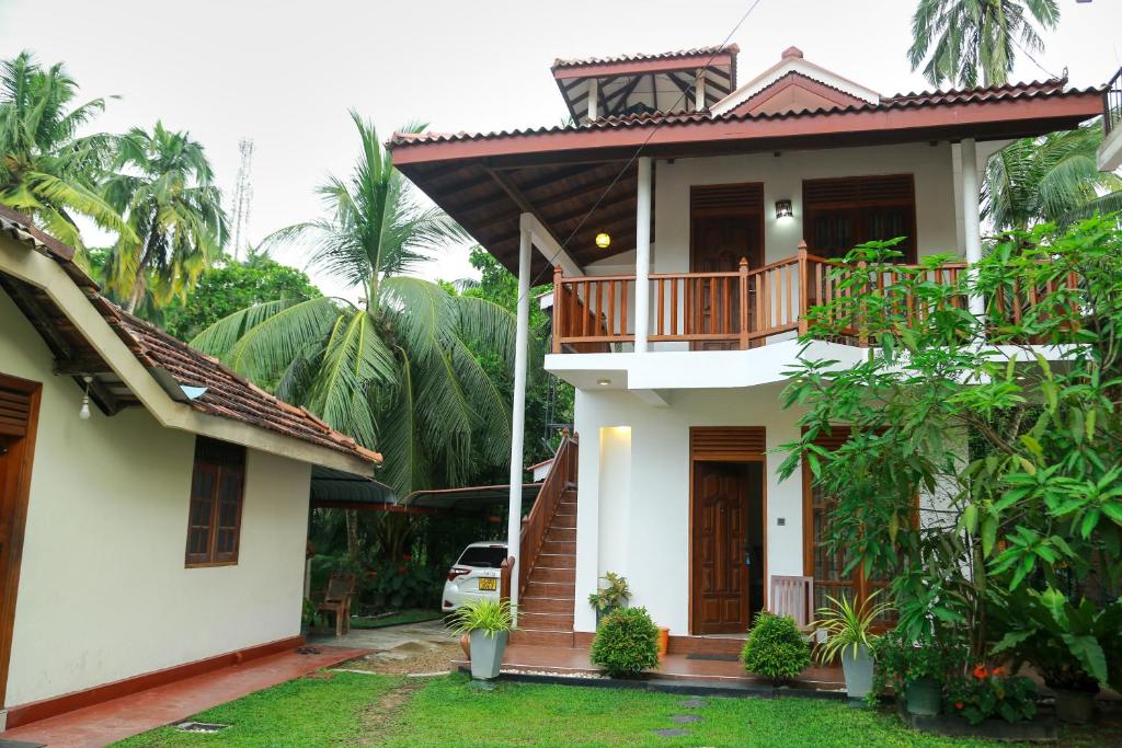 a white house with a balcony on top of it at Amara Guest in Mirissa