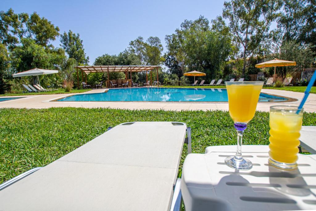 een tafel met twee glazen sinaasappelsap erop bij Tellis Holiday Rooms in Moraitika