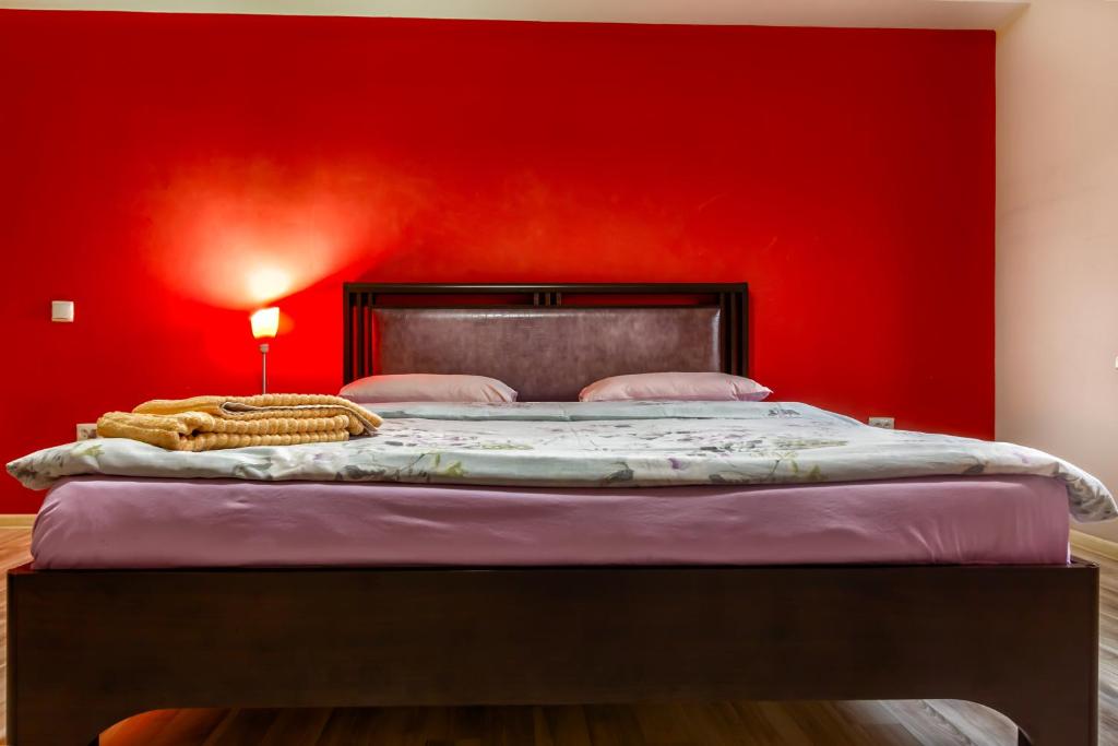a red bedroom with a bed with a red wall at 20 Traveler's Choice in the City Center in Almaty