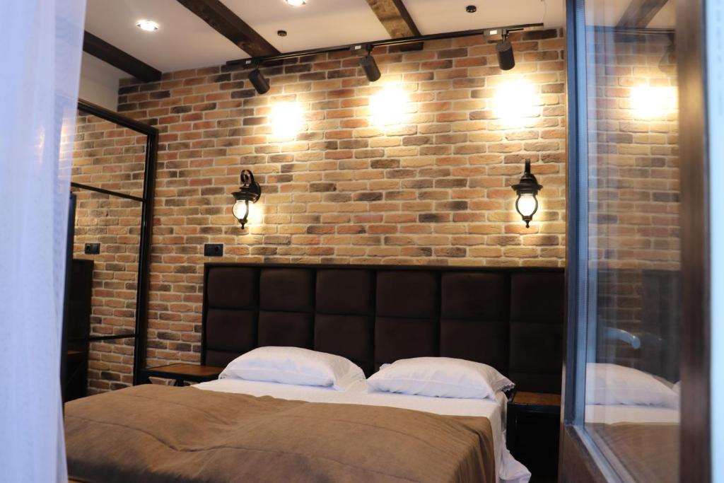 a bedroom with a bed and a brick wall at Шале Леона in Arkhyz
