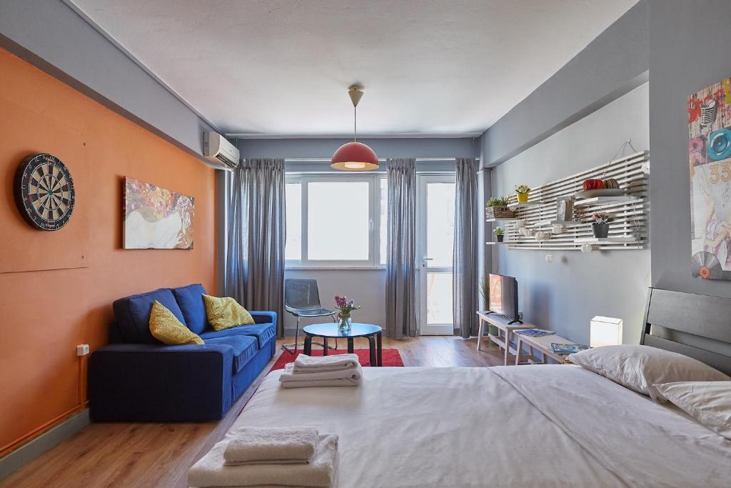 sypialnia z dużym łóżkiem i niebieską kanapą w obiekcie toStay-Unique apartment hotel in Athens center! w Atenach