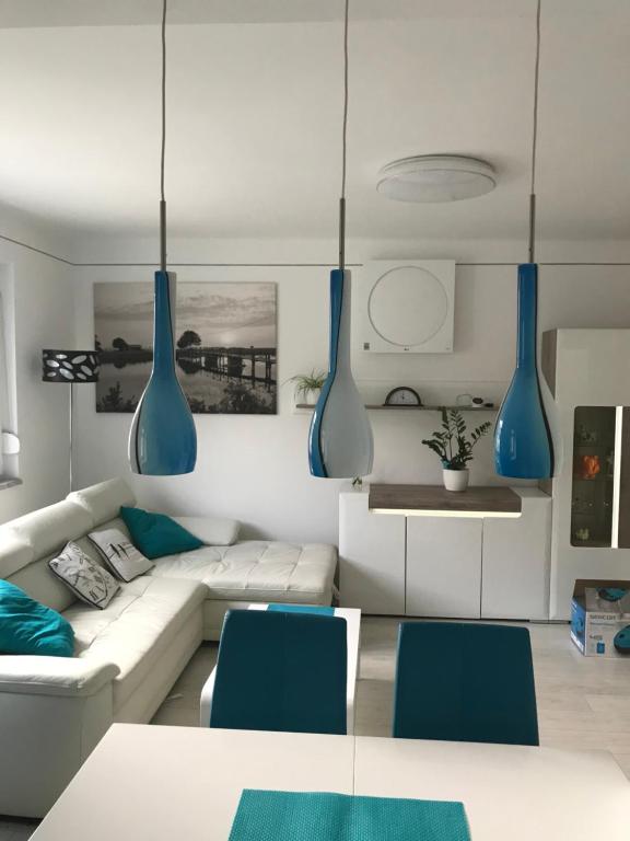 a living room with a white couch and blue vases at Belvárosi Luxus Apartman in Baja