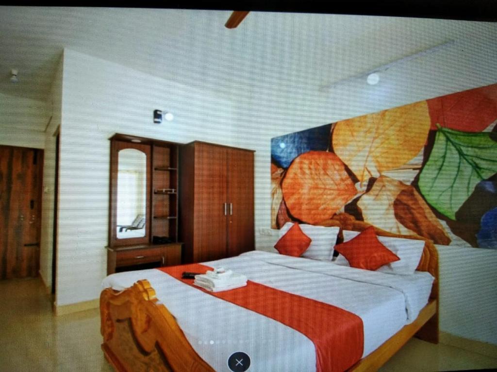 - une chambre avec un grand lit orné d'une peinture murale dans l'établissement A Ooty Honey Huts, à Ooty